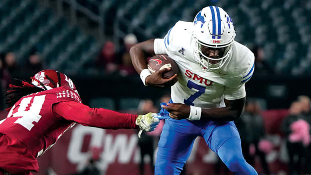 SMU Mustangs back-up quarterback Kevin Jennings runs with the ball against Temple Owls safety Brenyen Scott during the second half of a blowout win at Lincoln Financial Field.